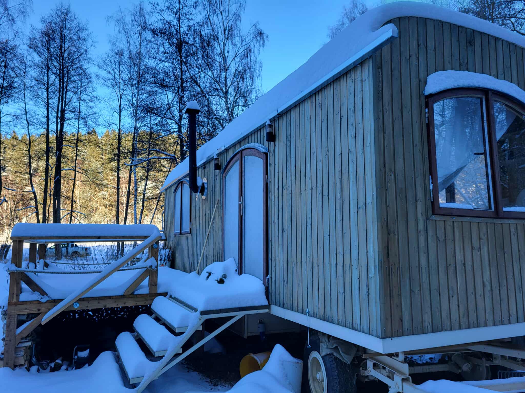 Útulný interiér maringotky s výhledem do přírody